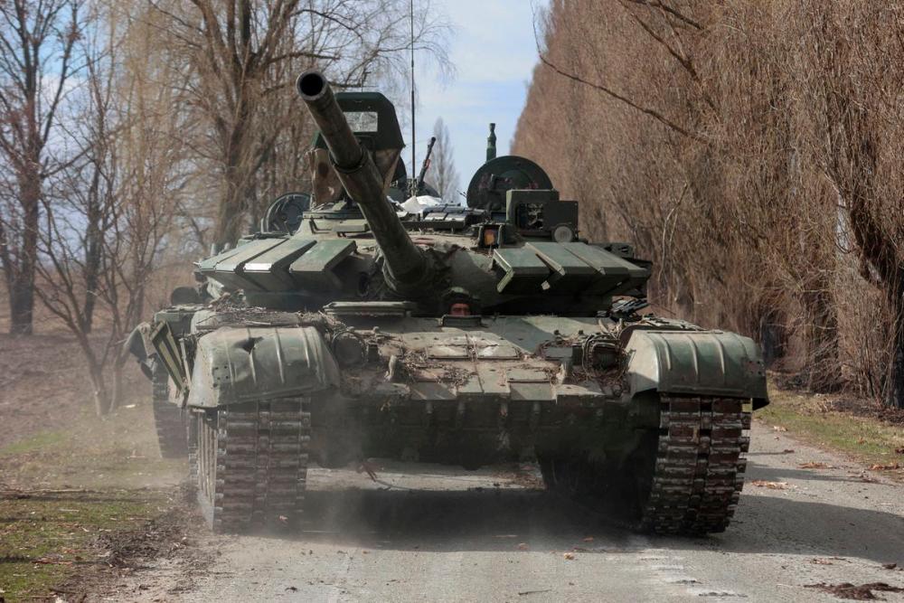 A Ukrainian service member drives a captured Russian T-72 tank, in the recently liberated village of Lukianivka, in Kyiv region, Ukraine March 27, 2022. REUTERSPIX