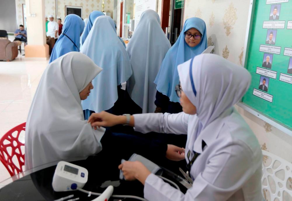 A student of the Institut Al Quran Darul Aman (Iqdar) has her blood pressure reading taken, at the Sultanah Bahiyah Hospital, on May 15, 2019. — BBX-Images