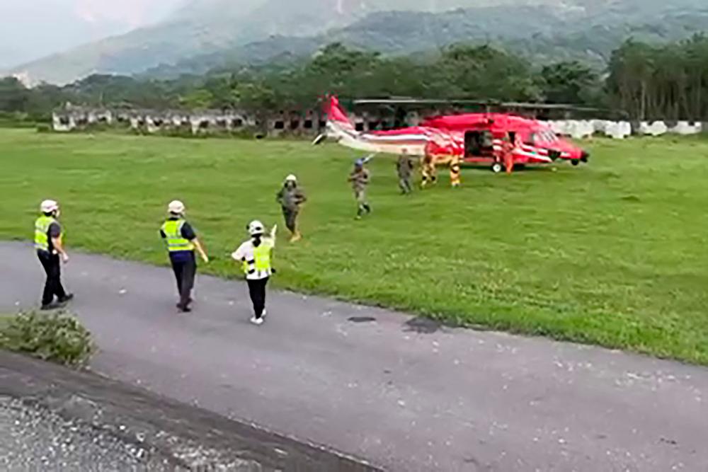 This screengrab from handout video from Taiwan’s Central Emergency Operation Center taken and released on April 4, 2024 shows workers disembarking from a helicopter after being rescued from a quarry in Hualien, following a major earthquake in Taiwan’s east/AFPPix- TAIWAN’S CENTRAL EMERGENCY OPERATIONS CENTER