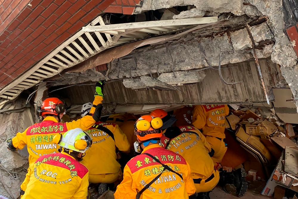 This handout from Taiwan’s National Fire Agency taken and released on April 3, 2024 shows members of a rescue team searching for survivors in a damaged building in Hualien, after a major earthquake hit Taiwan’s east/AFPPix