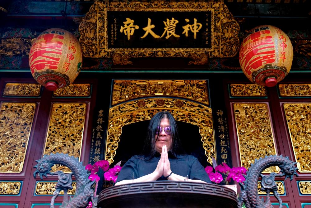 $!This picture taken on November 12, 2020 shows Jack Tung, drummer and founder of Taiwanese death metal band ‘Dharma’ praying at Baoan temple in Taipei. - AFP / Sam Yeh