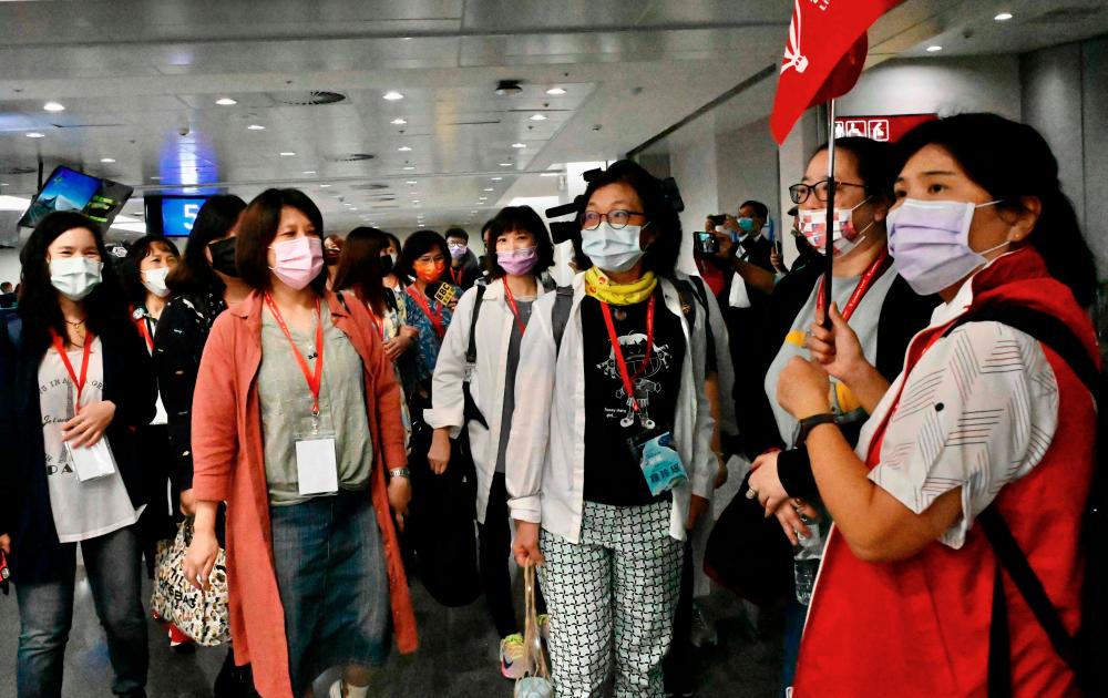 Taiwan tourists arrive at Taoyuan International Airport near Taipei on April 1, 2021, before heading to Palau as part of a travel bubble plan. -AFP