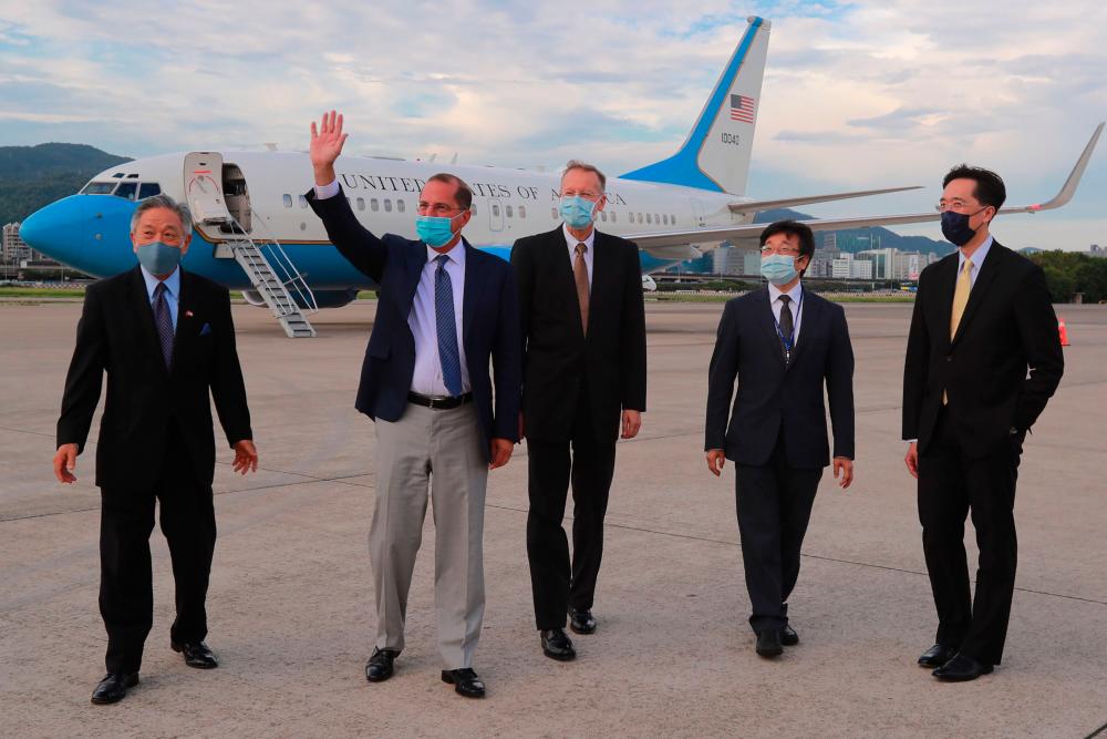 This handout photograph taken by Taiwan’s Ministry of Foreign Affairs on August 9, 2020 shows US Health Secretary Alex Azar (2nd L) waving following his arrival at the Sungshan Airport in Taipei. — AFP