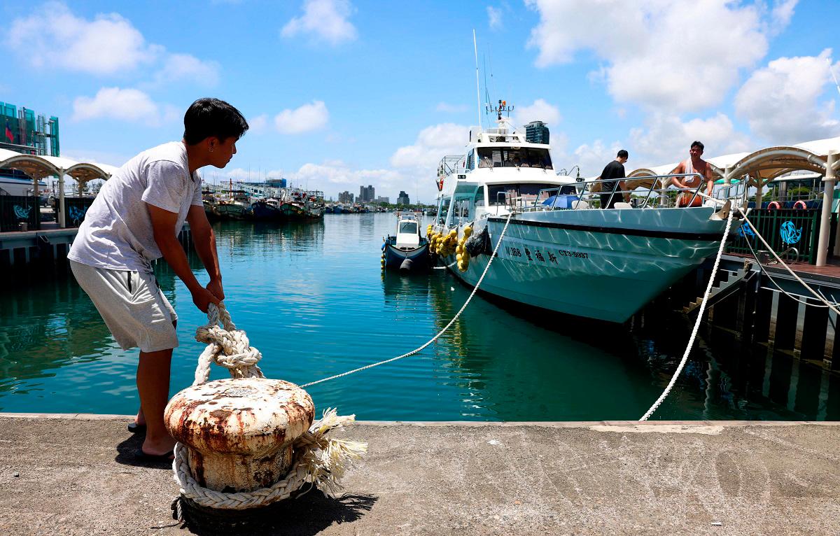 Fishermen secure their boats at Wushih Harbor in Yilan as Typhoon Podul approaches on August 12, 2025. - I-Hwa Cheng / AFP