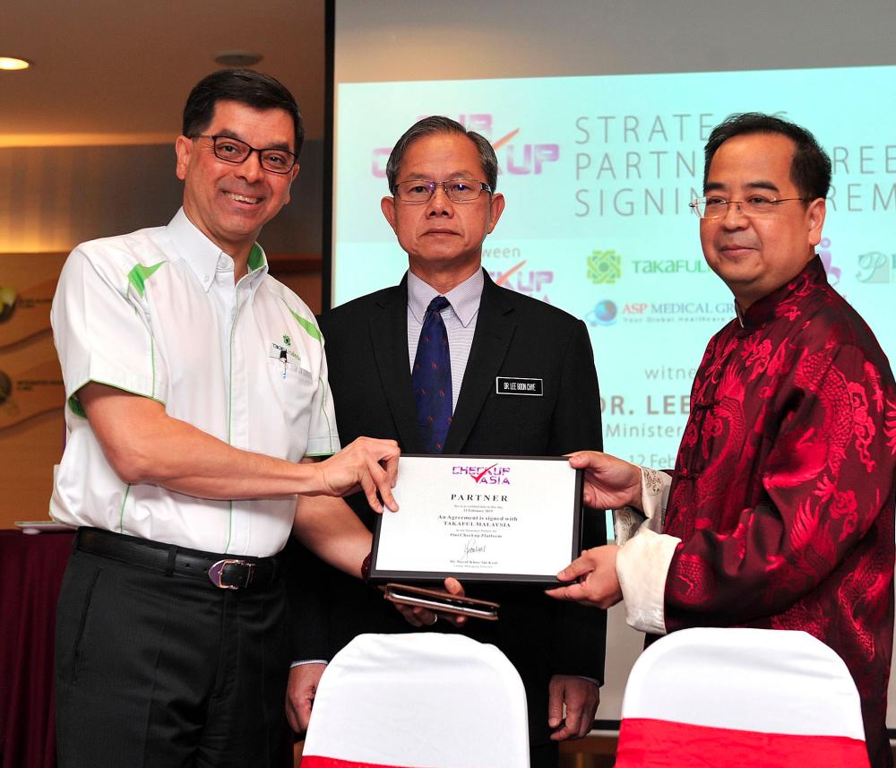 Mohamed Hassan (left) receiving a plaque from Khoo. Looking on is Deputy Health Minister Dr Lee Boon Chye.