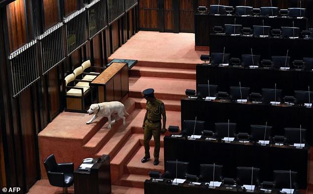 A policeman with a sniffer dog inspects parliament before the start of the session Thursday. — AFP