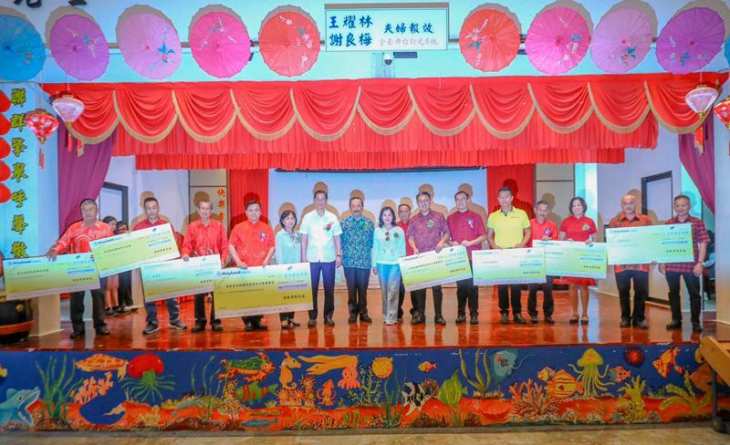 $!Tan, Esther and Lim (white shirt) with recipients of the contributions during the ceremony in Pulau Ketam. THESUN/AMIRUL SYAFIQ