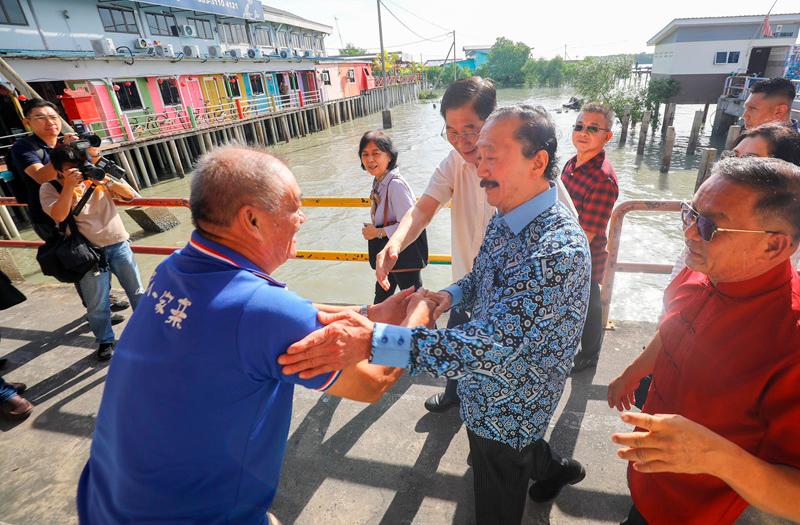 $!Tan is enthusiastically greeted by islanders upon arriving at the Pulau Ketam pier. THESUN/AMIRUL SYAFIQ