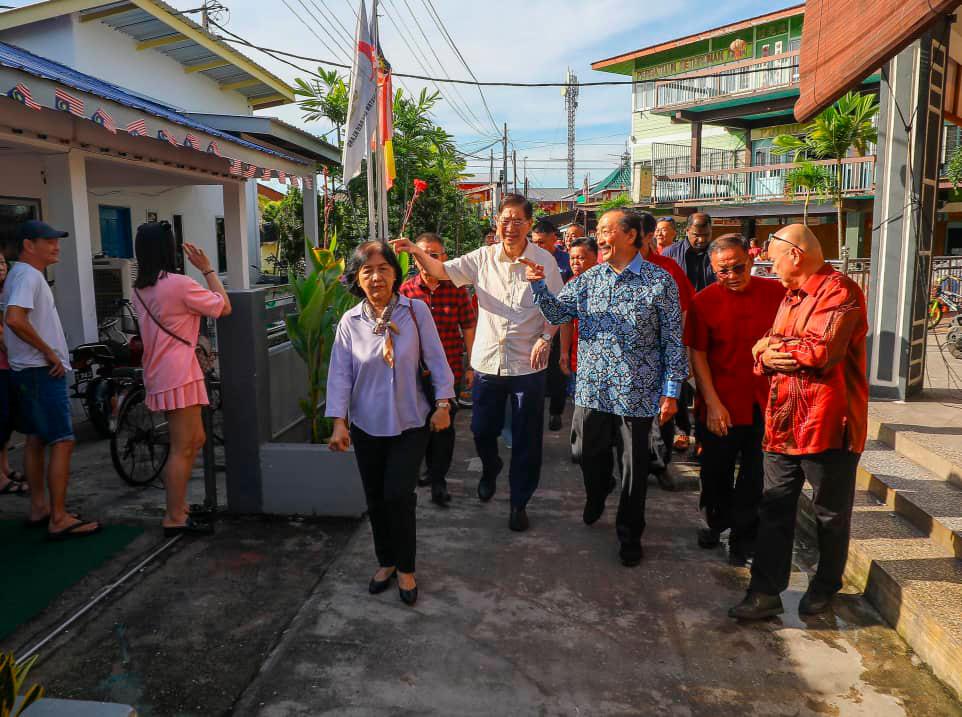 Tan, guided by Lim (white shirt), visits a village in Pulau Ketam during his first visit to the island. THESUN/AMIRUL SHAFIQ