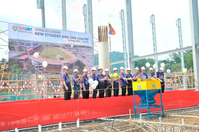 Datuk Seri Ir Dr Wee (sixth from right) pulling the lever and releasing cement at the topping out ceremony for the new Student and SME Centre at TAR UMT. On his right is Tan Sri Chan and on his left is Prof Ir Dr Lee.