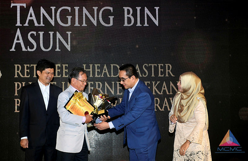 Retired headmaster Tanging Asun (2ndL) receives the Influential Volunteer Award from Malaysian Communications and Multimedia Commission (MCMC) chief digital officer Gerard Lim (2ndR) at the MIV Excellence Award ceremony, on April 30, 2019. — Bernama