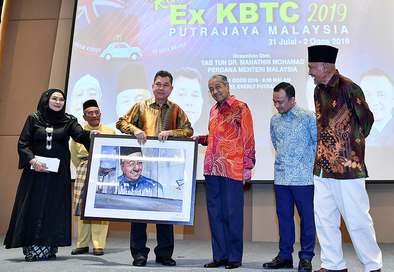 Prime Minister Tun Dr Mahathir Mohamad and ex-KTBC association’s patron Tengku Datuk Dr Hishammuddin Zaizi Tengku Azam Shah (3rd L), hold a potrait of the former which was up for bidding during a reunion ceremony, on Aug 1, 2019. — Bernama