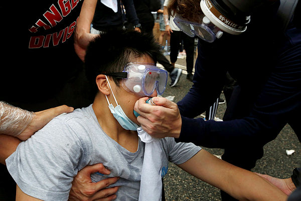 Protesters help a man during the demonstration where tear gas was fired, in Hong Kong, China June 12, 2019.