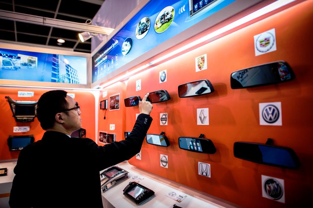 A man trying out a gadget on display at an electronics fair in Hong Kong. Hong Leong Investment Bank said global semiconductor sales for the first 11 months of 2018 were outstanding. AFPPIX