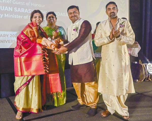 Vengkata presenting Malini with a bouquet during the anniversary and book launch.