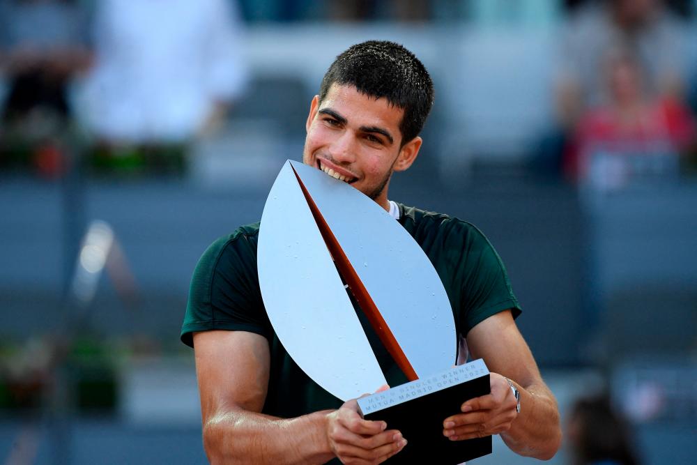 Spain’s Carlos Alcaraz poses for pictures with the trophy after winning the 2022 ATP Tour Madrid Open tennis tournament men’s singles final match against Germany’s Alexander Zverev at the Caja Magica in Madrid on May 8, 2022. AFPPIX