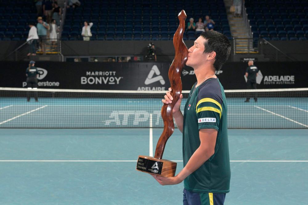 South Korea's Kwon Soon-woo poses with the trophy after winning against Spain's Roberto Bautista Agut during the men's singles final match at the ATP Adelaide International tournament in Adelaide on January 14, 2023 - AFPPIX