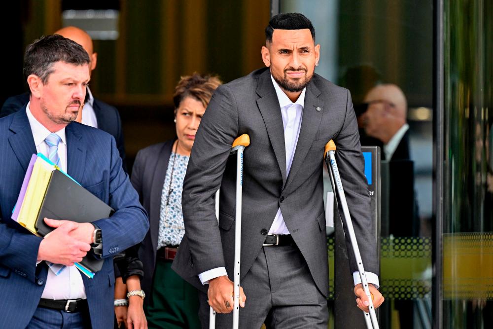 Australian tennis player Nick Kyrgios (R) leaves the magistrate’s court in Canberra on February 3, 2023. Kyrgios on Friday pleaded guilty to assaulting his then-girlfriend by pushing her to the ground in January 2021/AFPPix