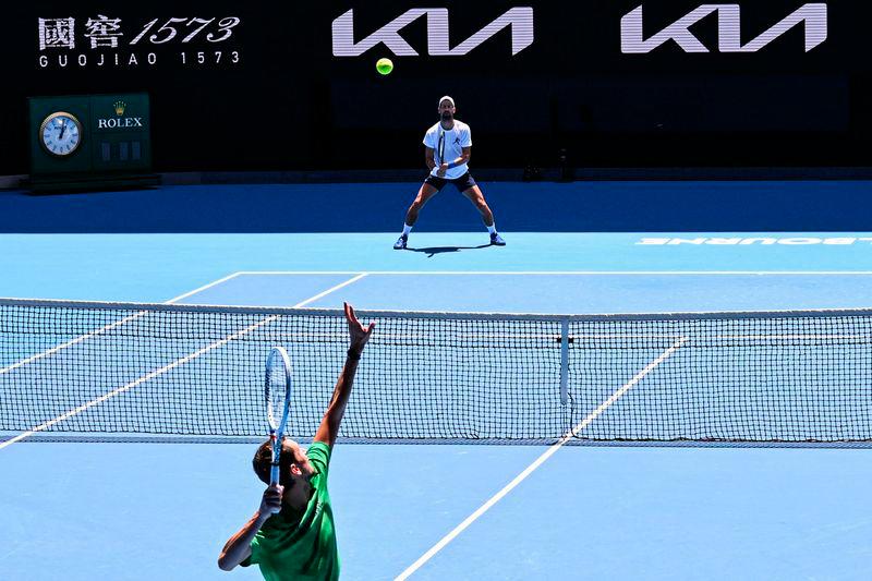 Serbia's Novak Djokovic (top) looks on as Russia's Daniil Medvedev serves during a practice session ahead of the Australian Open tennis tournament in Melbourne on January 11, 2025. - AFPPIX