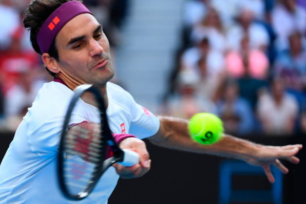 Switzerland's Roger Federer hits a return against Tennys Sandgren of the US during their men's singles quarter-final match on day nine of the Australian Open tennis tournament in Melbourne on January 28, 2020. - AFP