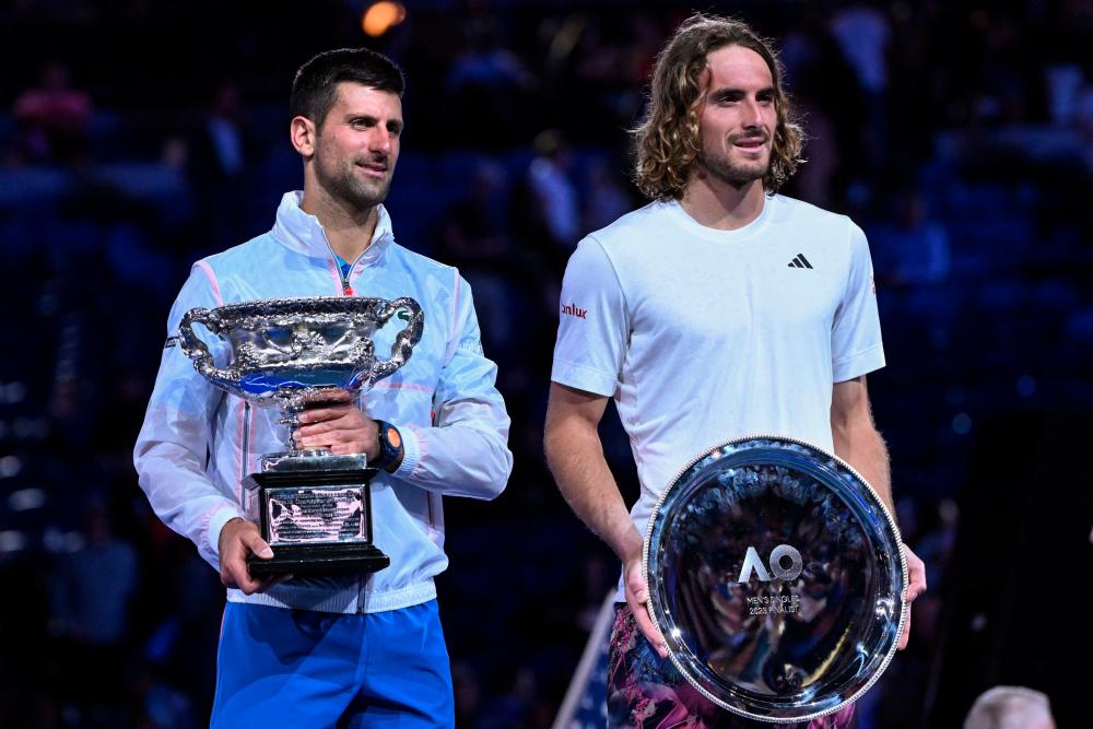 Serbia’s Novak Djokovic (L) holding the Norman Brookes Challenge Cup poses with Greece’s Stefanos Tsitsipas (R) afer his victory during the men’s singles final on day fourteen of the Australian Open tennis tournament in Melbourne on January 29, 2023. AFPPIX