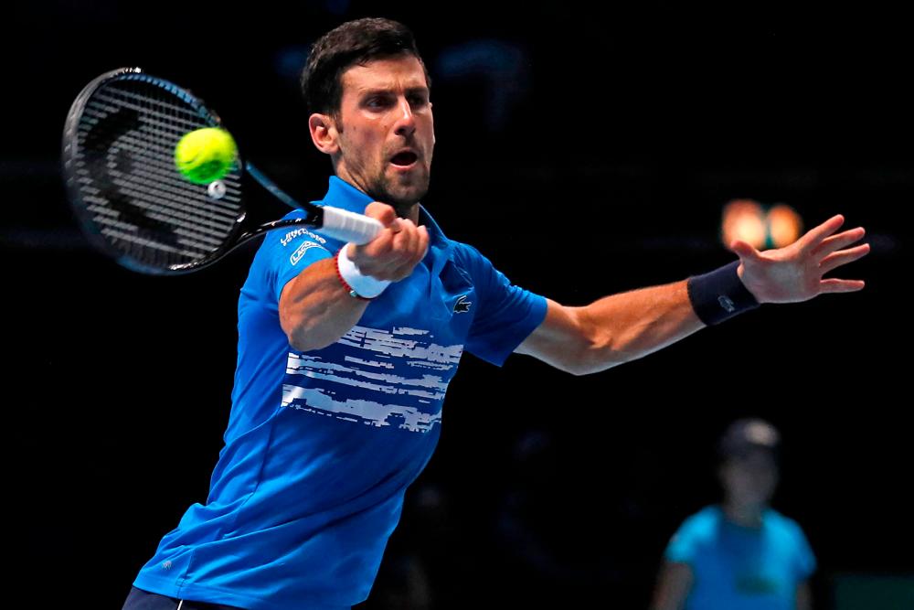 Serbia's Novak Djokovic returns against Italy's Matteo Berrettini during their men's singles round-robin match on day one of the ATP World Tour Finals tennis tournament at the O2 Arena in London on November 10, 2019. - AFP