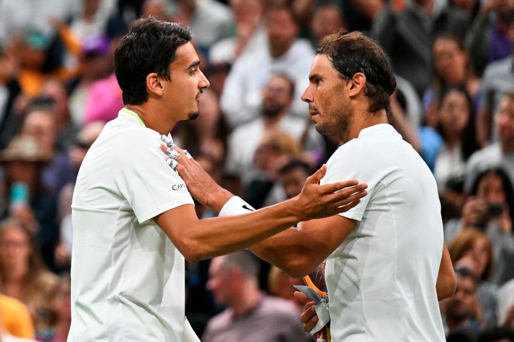 Spain's Rafael Nadal (R) speaks with Italy's Lorenzo Sonego (L) after winning in their men's singles tennis match on the sixth day of the 2022 Wimbledon Championships at The All England Tennis Club in Wimbledon, southwest London, on July 2, 2022. AFPPIX