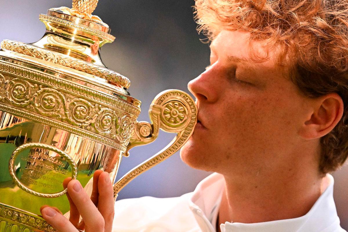 Italy’s Jannik Sinner kisses the winner’s trophy as he poses for pictures following his victory against Spain’s Carlos Alcaraz at the end of their men’s singles final tennis match on the fourteenth day of the 2025 Wimbledon Championships at The All England Lawn Tennis and Croquet Club in Wimbledon, southwest London, on July 13, 2025. - AFP