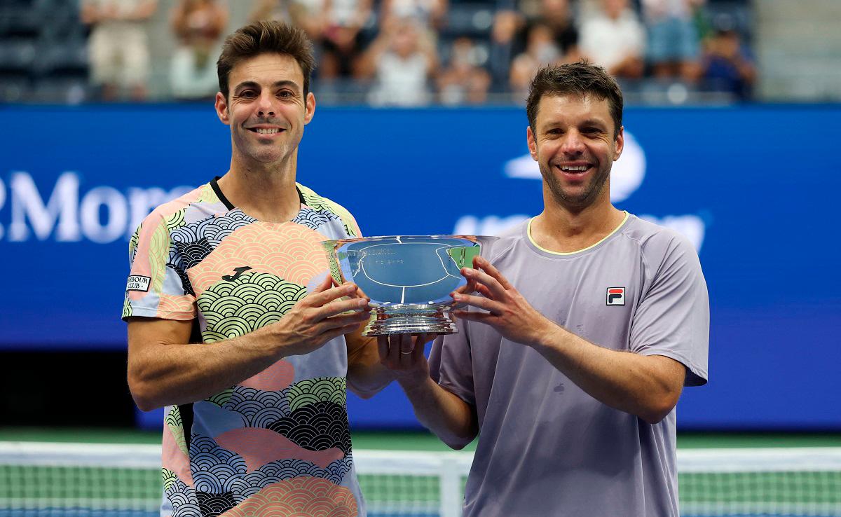 Spain’s Marcel Granollers (L) and Argentina’s Horacio Zeballos pose with the trophy after winning the men’s doubles championship title. - TIMOTHY A. CLARY / AFP