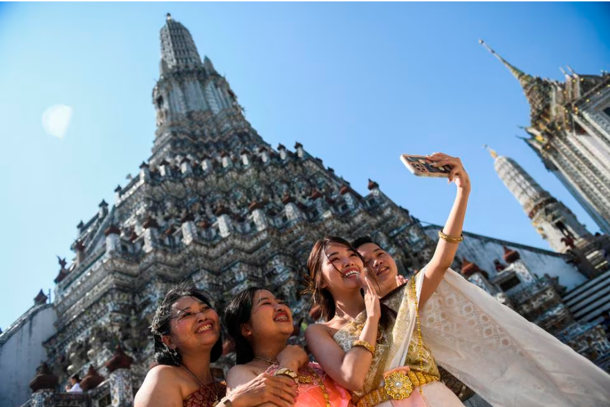 Vietnamese tourists dressed in traditional Thai costumes take a selfie at Wat Arun temple ahead of the Chinese Lunar New Year in Bangkok, Thailand January 18, 2023. REUTERSpix