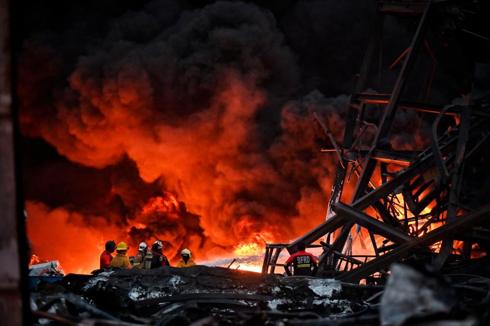 Firefighters work at the site of an explosion and fire at a plastics factory on the outskirts of Bangkok on July 5, 2021. – AFP