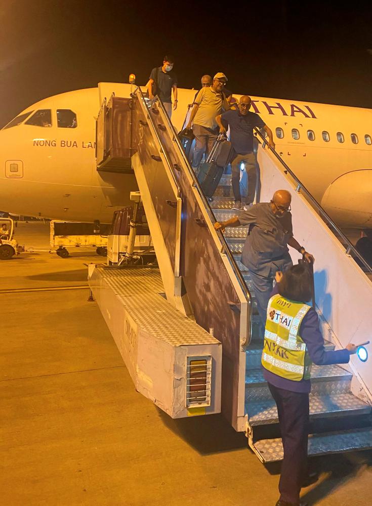 This UGC photo taken on February 7, 2024 and posted by Facebook user Watcharapon Pethsurp on February 9 shows passengers disembarking a Thai Airways plane at Chiang Mai Airport in Chiang Mai, following a passenger's attempt to open an emergency exit door. - AFPPIX
