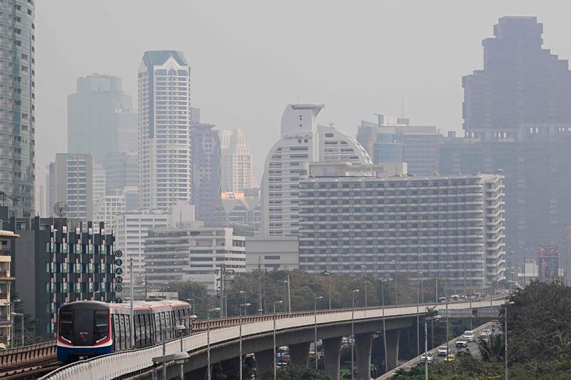 A BTS Skytrain runs along its tracks amid high levels of air pollution in Bangkok on January 24, 2025. Air pollution in the Thai capital forced the closure of more than 350 schools on January 24, city authorities said, the highest number in five years. Bangkok officials announced free public transport for a week in a bid to reduce traffic in a city notorious for noxious exhaust fumes. - Lillian SUWANRUMPHA / AFP