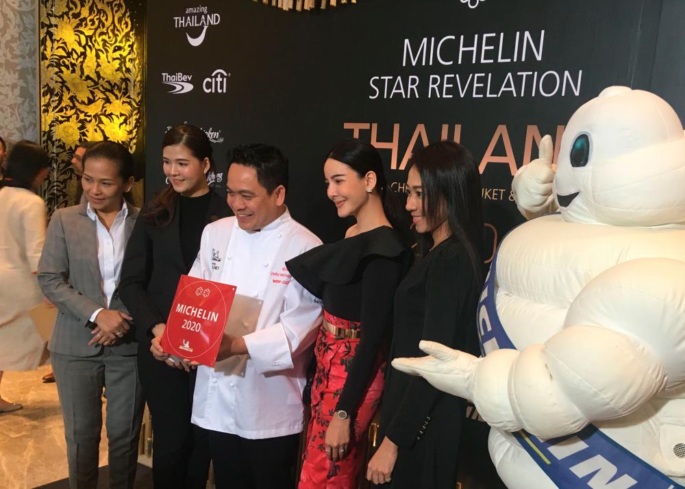 In this photo taken on November 11, 2019, Thai chef Chumpol (3rd L) holds the two Michelin stars award during a ceremony in Bangkok. Two traditional cuisine restaurants that have been awarded two Michelin stars, a first for the gastronomy of this Asian country renowned throughout the world. / AFP / Stéphane DELFOUR