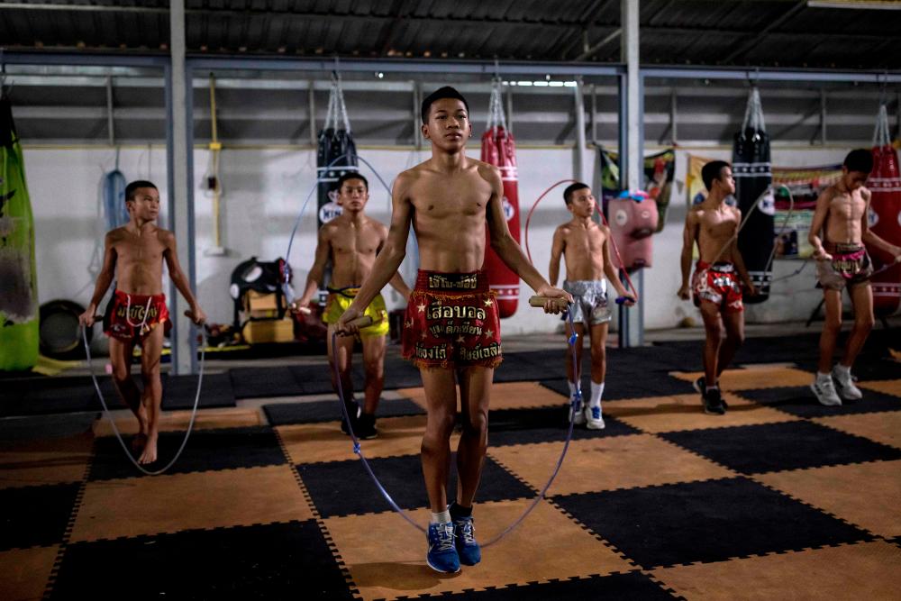 In this photo taken on September 14, 2022, young Muay Thai boxers jump over skipping rope during a training session at a Muay Thai gym in Nonthaburi, northwest of the Thai capital Bangkok. – AFPPIX