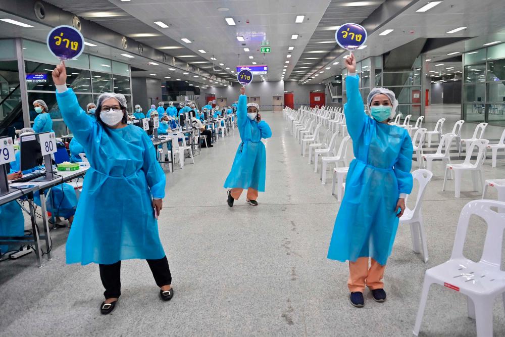 Health workers call for people to receive doses of the Covid-19 coronavirus CoronaVac vaccine at Bang Sue Central Station in Bangkok on May 24, 2021. AFPpix