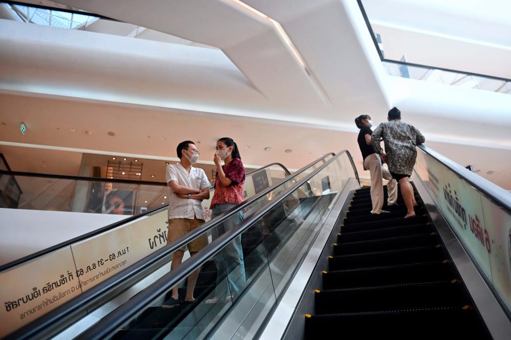 People riding the escalators at a shopping mall in Bangkok. A study shows consumer spending is likely to be weak for another three to six months, – REUTERSPIX