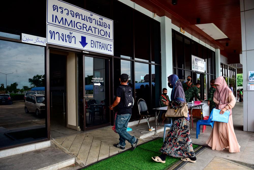 Malaysian tourists walk into the Thai customs building in Sungai Kolok district in southern Thailand’s Narathiwat province on June 1, 2022, after Malaysia and Thailand re-opened their land borders following the loosening of restrictions related to the Covid-19 coronavirus. AFPPIX