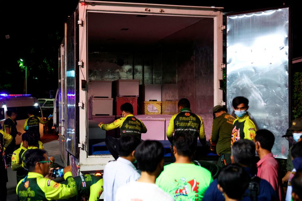 Rescue workers stand next to coffins containing the bodies of victims at Udon Thani hospital in Udon Thani province, following a mass shooting in the town of Uthai Sawan, around 500 km northeast of Bangkok in the province of Nong Bua Lam Phu, Thailand October 7, 2022. REUTERSPIX