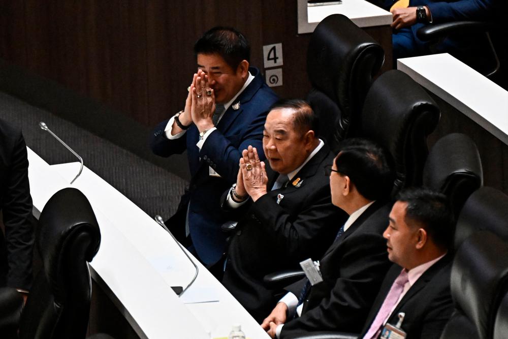 Palang Pracharath party leader and deputy prime minister Prawit Wongsuwan (C) and Thammanat Prompao (L) gesture before the vote to decide the country’s next prime minister in Bangkok on July 13, 2023. AFPPIX