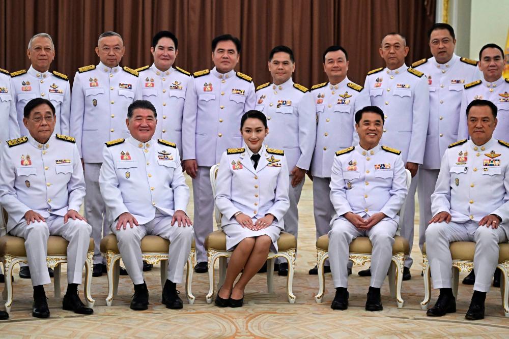 Thailand's Prime Minister Paetongtarn Shinawatra (bottom C), known by her nickname Ung Ing and daughter of former prime minister Thaksin Shinawatra, poses with cabinet members for a group photo at Government House in Bangkok on September 6, 2024, ahead of a royal oath-taking ceremony for her cabinet. - Lillian SUWANRUMPHA / AFP