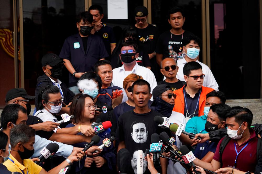 Anti-government protesters leaders Panusaya Rung Sithijirawattanakul, Panupong Mike Jadnok, Jatupat Pai Boonpattararaksa and other leaders speak as they arrive to report themselves over royal insult charges, at the Attorney General's office in Bangkok, Thailand March 8, 2021. — Reuters