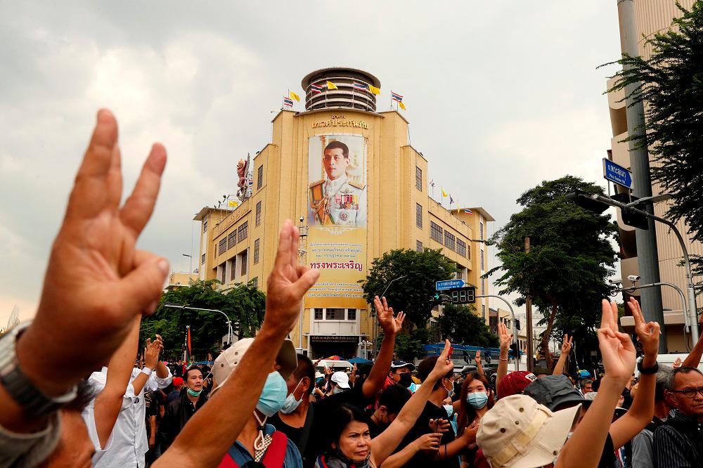 A portrait of King Maha Vajiralongkorn is seen as pro-democracy demonstrators give a three-finger salute while marching during a Thai anti-government mass protest in Bangkok October 14, 2020.― Reuters