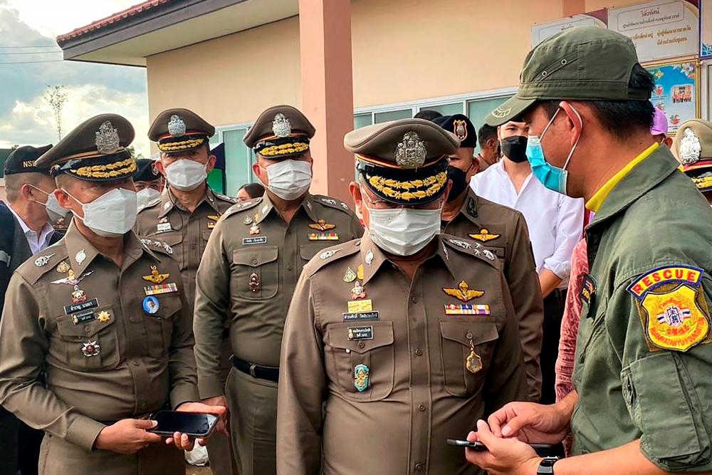 National Police Chief, Damrongsak Kittiprapat (2R), speaking with rescue workers at the nursery following in a mass shooting, in the northern Thai province of Nong Bua Lam Phu. AFPPIX