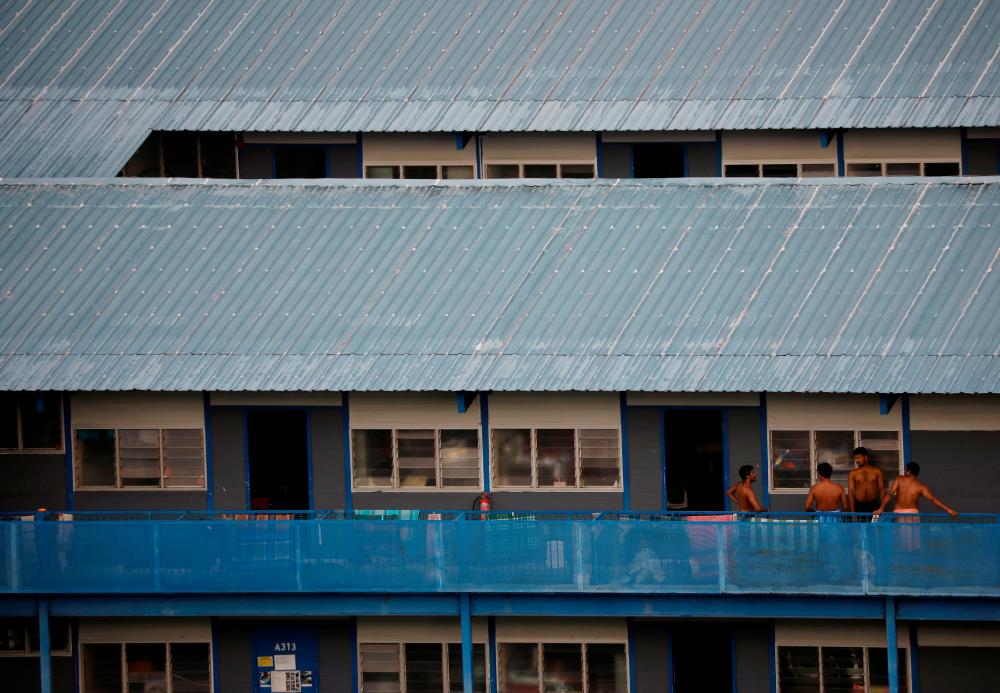 Migrant workers chat outside their rooms at a dormitory declared as an isolation area, amid the coronavirus disease (Covid-19) outbreak in Singapore May 4, 2020. - Reuters