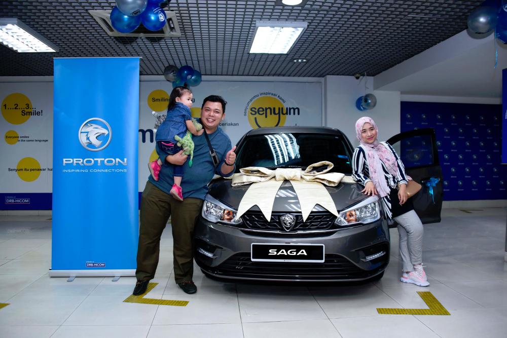 Azrul Firdaus, isterinya dan anak mereka bersama Proton Saga Premium AT yang dimenanginya.