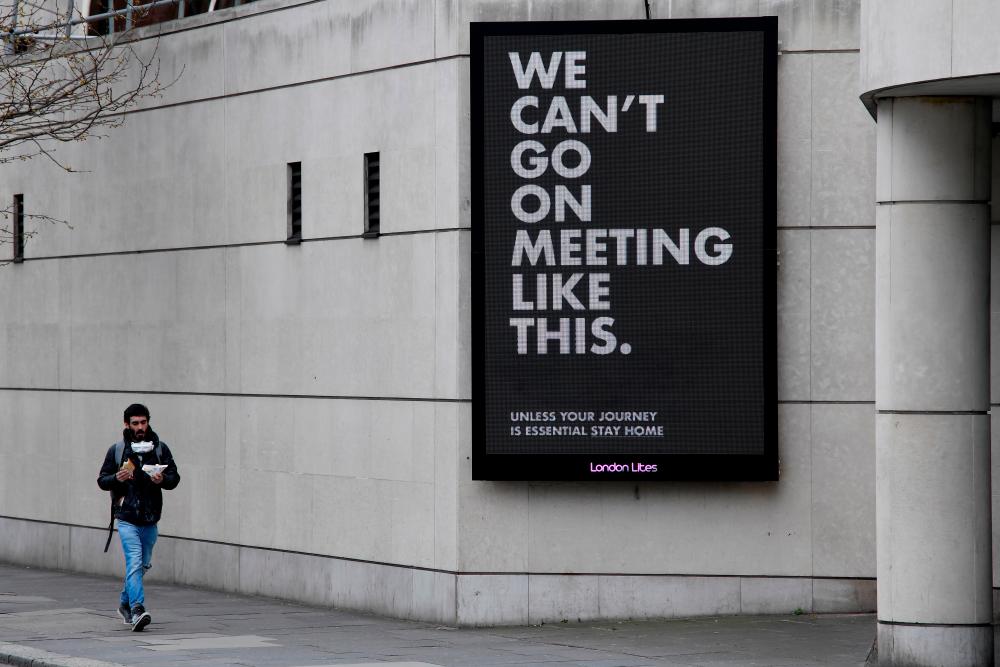 A man walks past a Public Health campaign as the spread of the coronavirus disease (Covid-19) continues, London, Britain, March 31, 2020. - Reuters