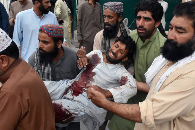 Men move an injured man after a suicide attack during an election campaign meeting, outside a hospital in Quetta, Pakistan on July 13 — Reuters