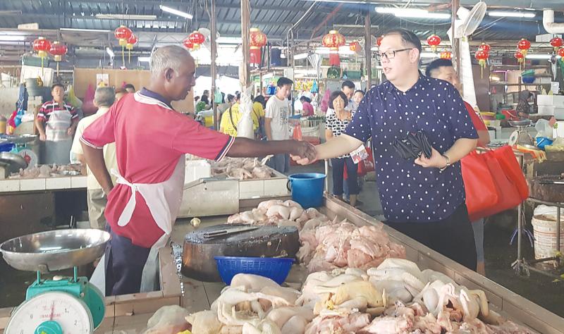 Lee chats with a trader at a wet market.