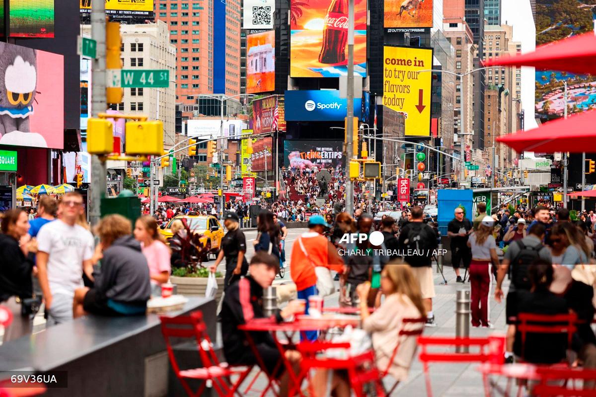 Pedestrians and vehicles move through Times Square in the Manhattan borough of New York City on August 18, 2025. - CHARLY TRIBALLEAU / AFP